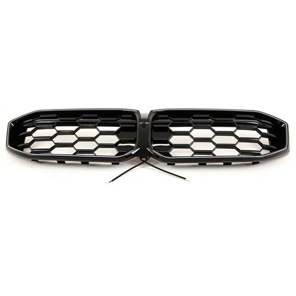 A hexagonal-patterned car grille with black finish, featuring a central wiring connection, is positioned on a plain white background.
