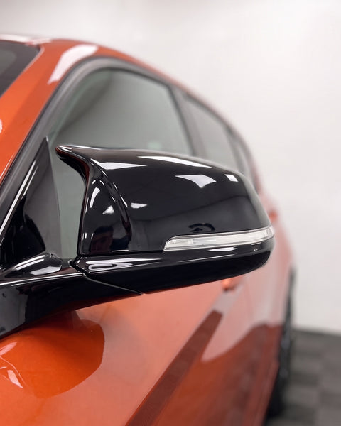 Close-up of a gloss black M-style wing mirror cover on a BMW 1 Series F20 | Carbon Accents