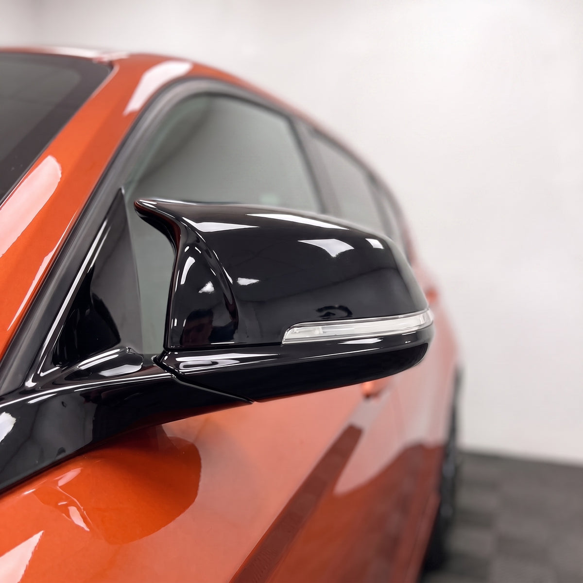 Close-up of a gloss black M-style wing mirror cover on a BMW 1 Series F20 | Carbon Accents