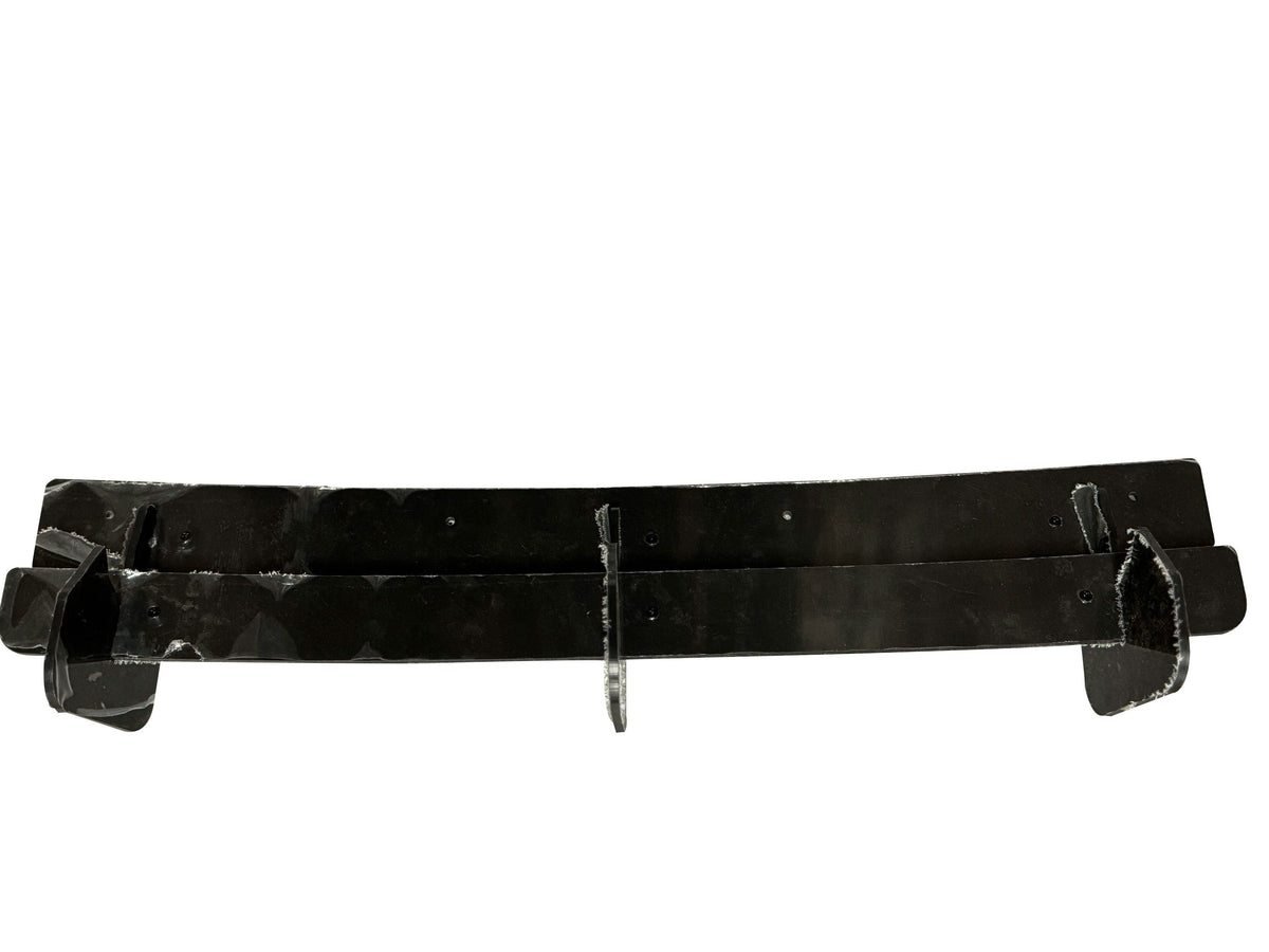A black, elongated object with three attached hooks is resting horizontally. The shiny surface and rectangular shape suggest it could be a type of holder or mounting device. The background is plain white.