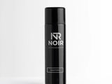 Black aerosol can standing upright on a white surface, labeled 