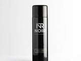 A black aerosol can stands upright, labeled 