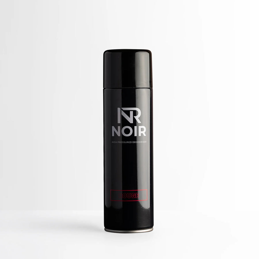 A black aerosol can labeled “NR NOIR” and “HIGH PRESSURED DEODORISER” stands upright on a plain white surface. The word “ROUGE” is in red near the base.