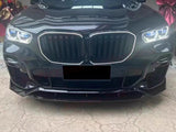 A black car's front view shows a large grille and illuminated headlights, parked on a concrete surface. Red ribbons in the background suggest a celebratory or gifting context.