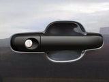 A black car door handle with a keyhole is centered on a glossy, dark gray vehicle surface, reflecting a cloudy sky in the background.