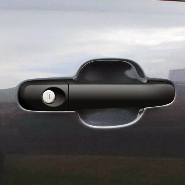 A black car door handle with a keyhole is centered on a glossy, dark gray vehicle surface, reflecting a cloudy sky in the background.