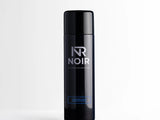 A black cylindrical deodorant can stands upright on a white surface. Text on the can reads 