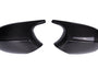 Two black carbon fiber car mirror covers are placed side by side on a plain white background, showcasing a glossy finish and a textured pattern.