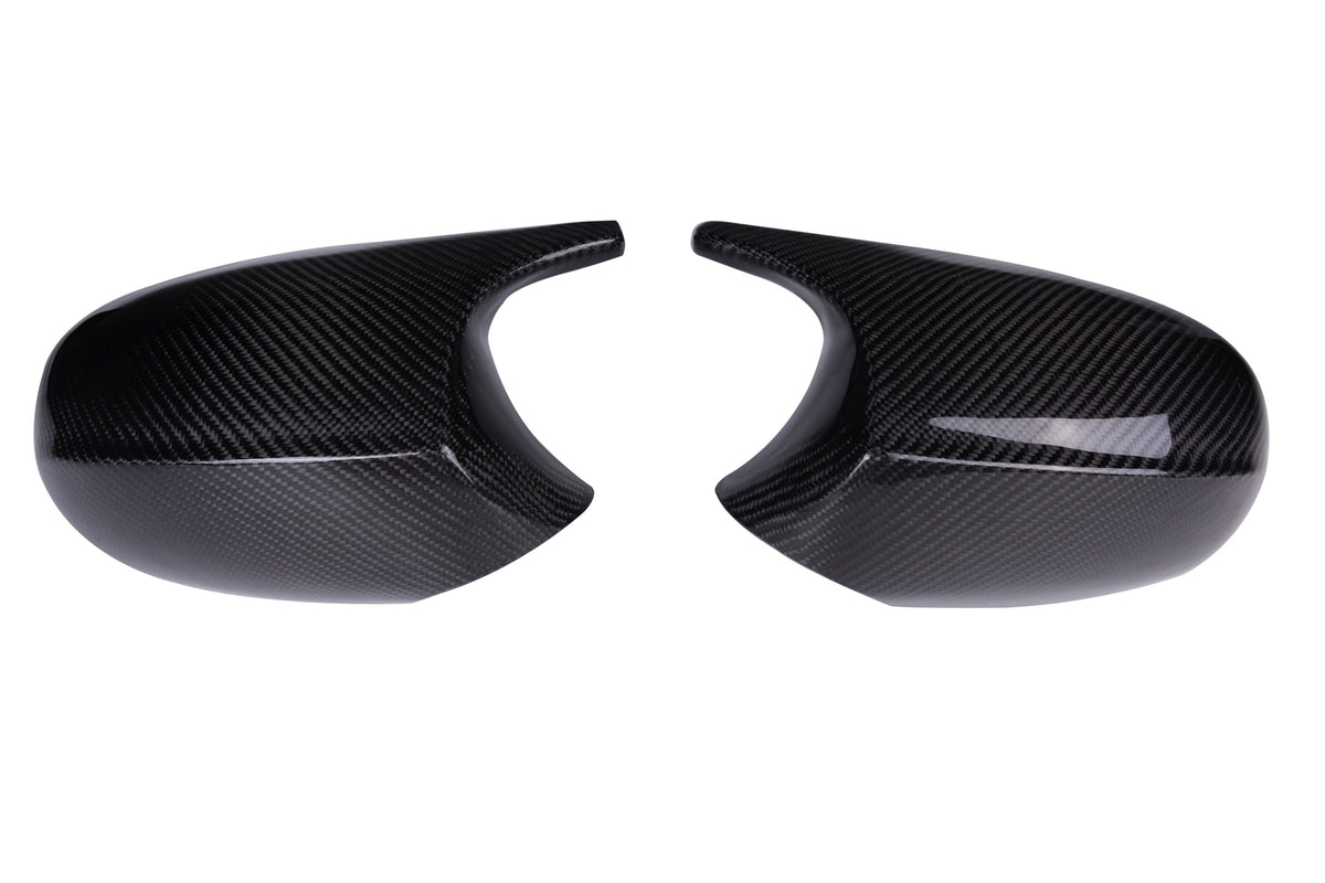 Two black carbon fiber car mirror covers are placed side by side on a plain white background, showcasing a glossy finish and a textured pattern.