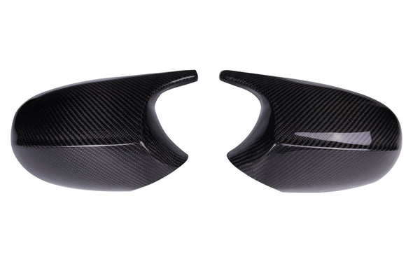 Two black carbon fiber car mirror covers are placed side by side on a plain white background, showcasing a glossy finish and a textured pattern.