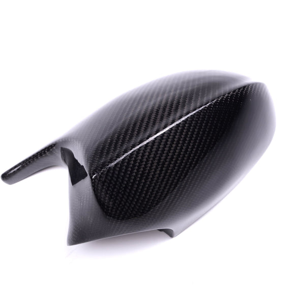 Carbon fiber car mirror cover, resting stationary, on a plain white background. The cover reflects light with a subtle pattern, indicating its sleek and lightweight design.