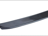 A carbon fiber ski tip, curved slightly upward, features a textured pattern. It is set against a plain white background, emphasizing the sleek design and material.