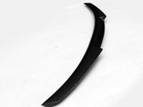 A curved, black car spoiler with a textured surface rests on a plain white background.