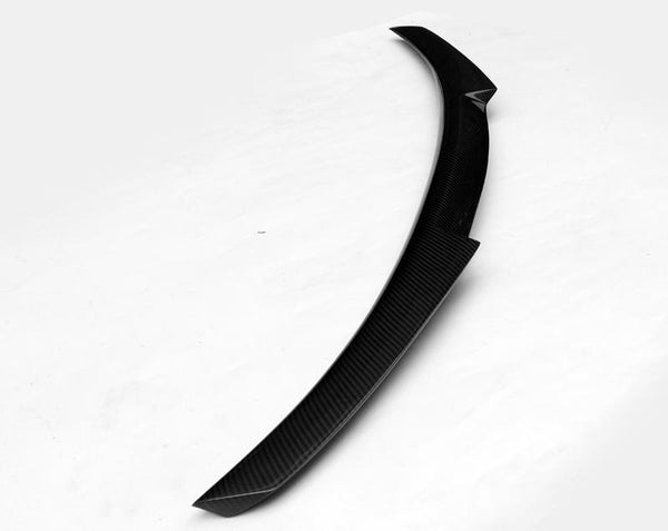 A curved, black car spoiler with a textured surface rests on a plain white background.