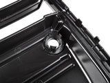 A glossy black plastic automotive part with a circular mount and ridges is shown in close-up, likely part of a larger engine or mechanical assembly.