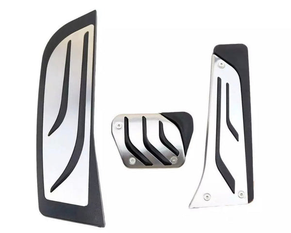 Three metallic vehicle pedal covers feature sleek black accents and grooves. They are designed for installation on an automobile's accelerator, brake, and clutch pedals, set against a plain white background.