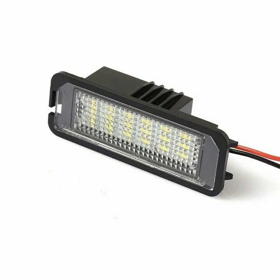 Rectangular LED light with multiple yellow diodes, installed in a black housing. It features a textured lens cover and is connected to red and black wires, set against a plain white background.