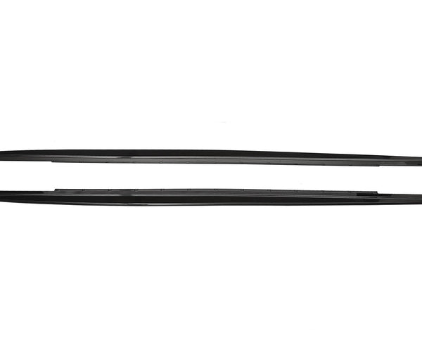 Two sleek, black car side skirts, aligned horizontally, lie against a plain white background, showing their aerodynamic design and smooth edges.