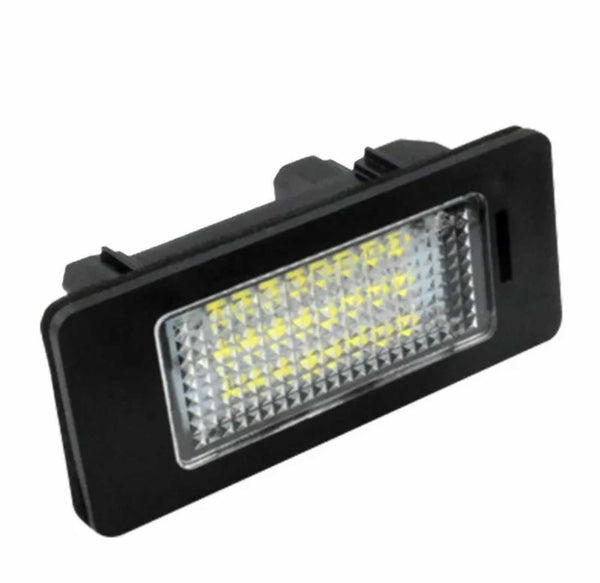 A rectangular LED light fixture with a black frame and checkered lens, angled slightly upward, displaying multiple small yellow lights. The background is plain white.