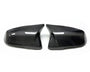 Two glossy carbon fiber car mirror covers, facing each other, are placed on a white background, highlighting their sleek and modern design.