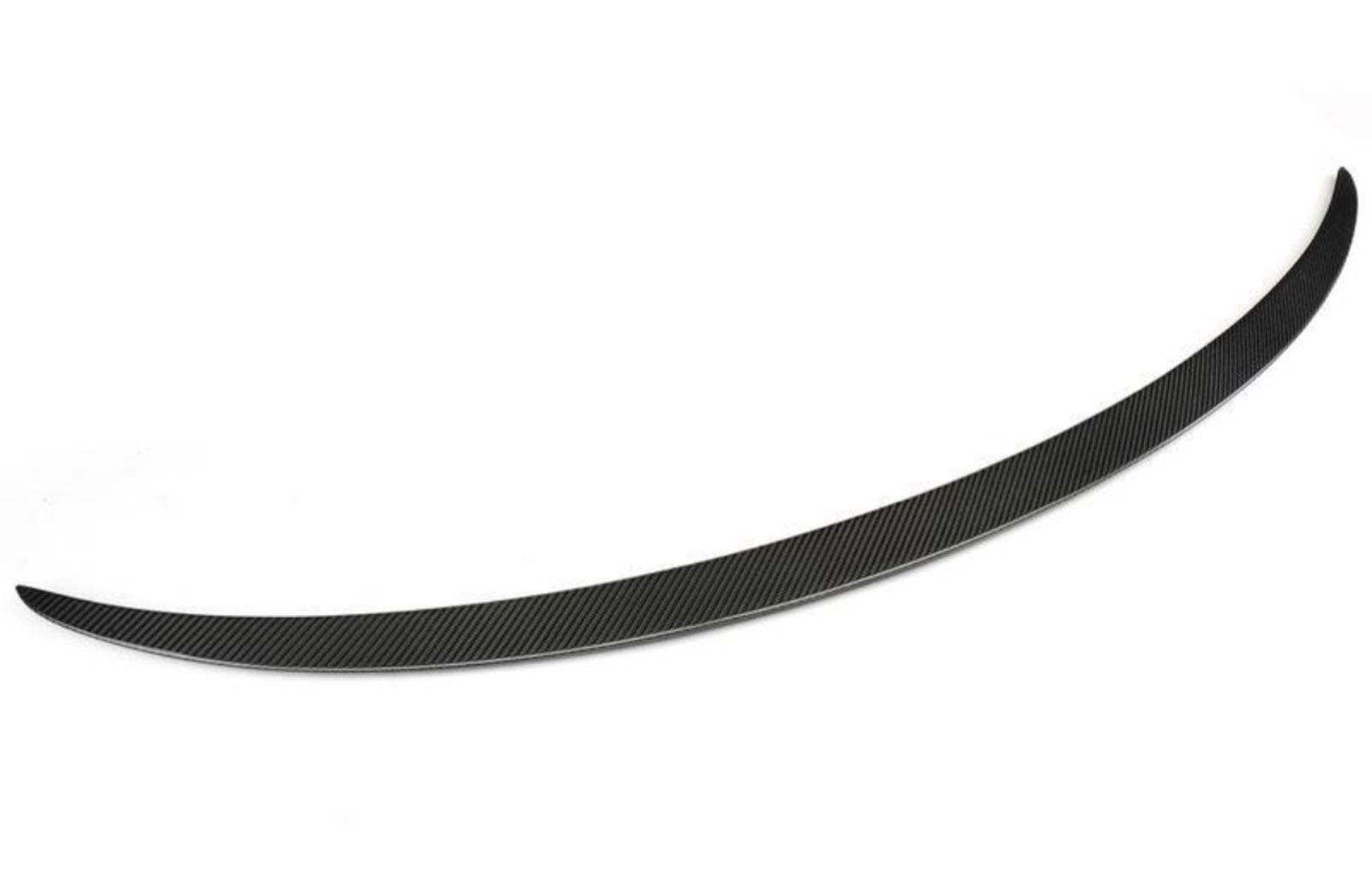 A sleek, curved black carbon fiber spoiler blade rests on a white background, showcasing a finely textured surface with diagonal patterns, designed to enhance vehicle aerodynamics.