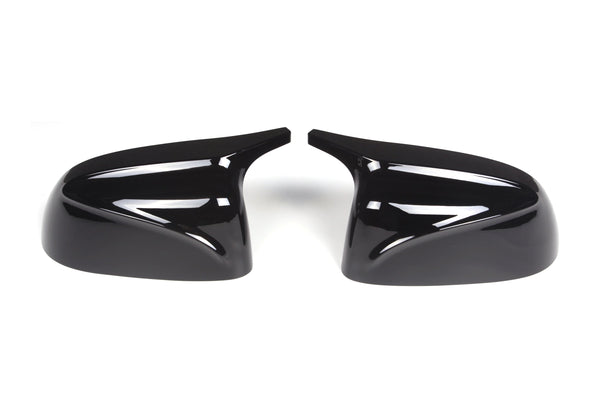 Two glossy black side mirror covers positioned symmetrically, facing each other against a white background, designed for automotive use.