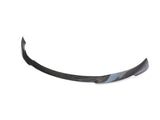 Curved carbon fiber car bumper lip rests on a white background, showcasing its sleek, aerodynamic design intended for vehicle front-end attachment.