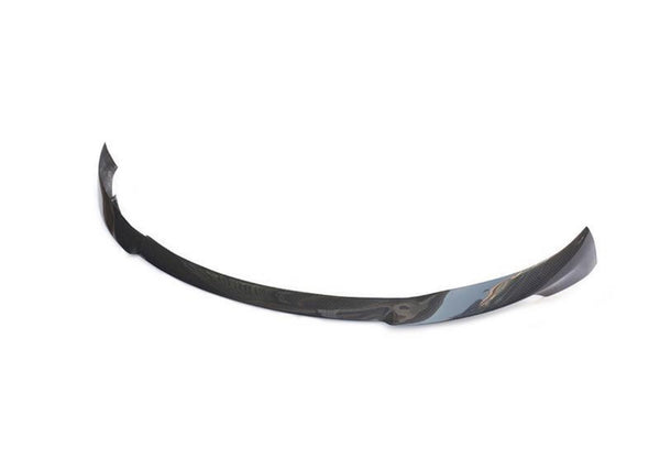 Curved carbon fiber car bumper lip rests on a white background, showcasing its sleek, aerodynamic design intended for vehicle front-end attachment.