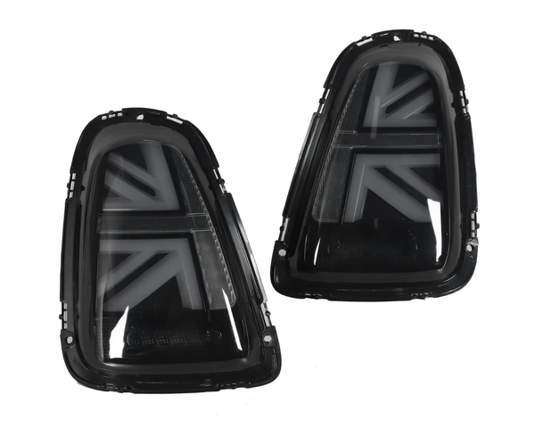 Two black car taillights with arrow-shaped patterns are positioned side by side, facing forward, against a white background, showcasing their glossy finish and angular design.