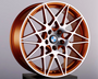 A copper-colored alloy wheel with a complex, multi-spoke design rests on a black pedestal. The BMW logo is in the center. The background is a plain light gray.