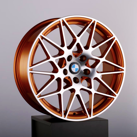 A copper-colored alloy wheel with a complex, multi-spoke design rests on a black pedestal. The BMW logo is in the center. The background is a plain light gray.