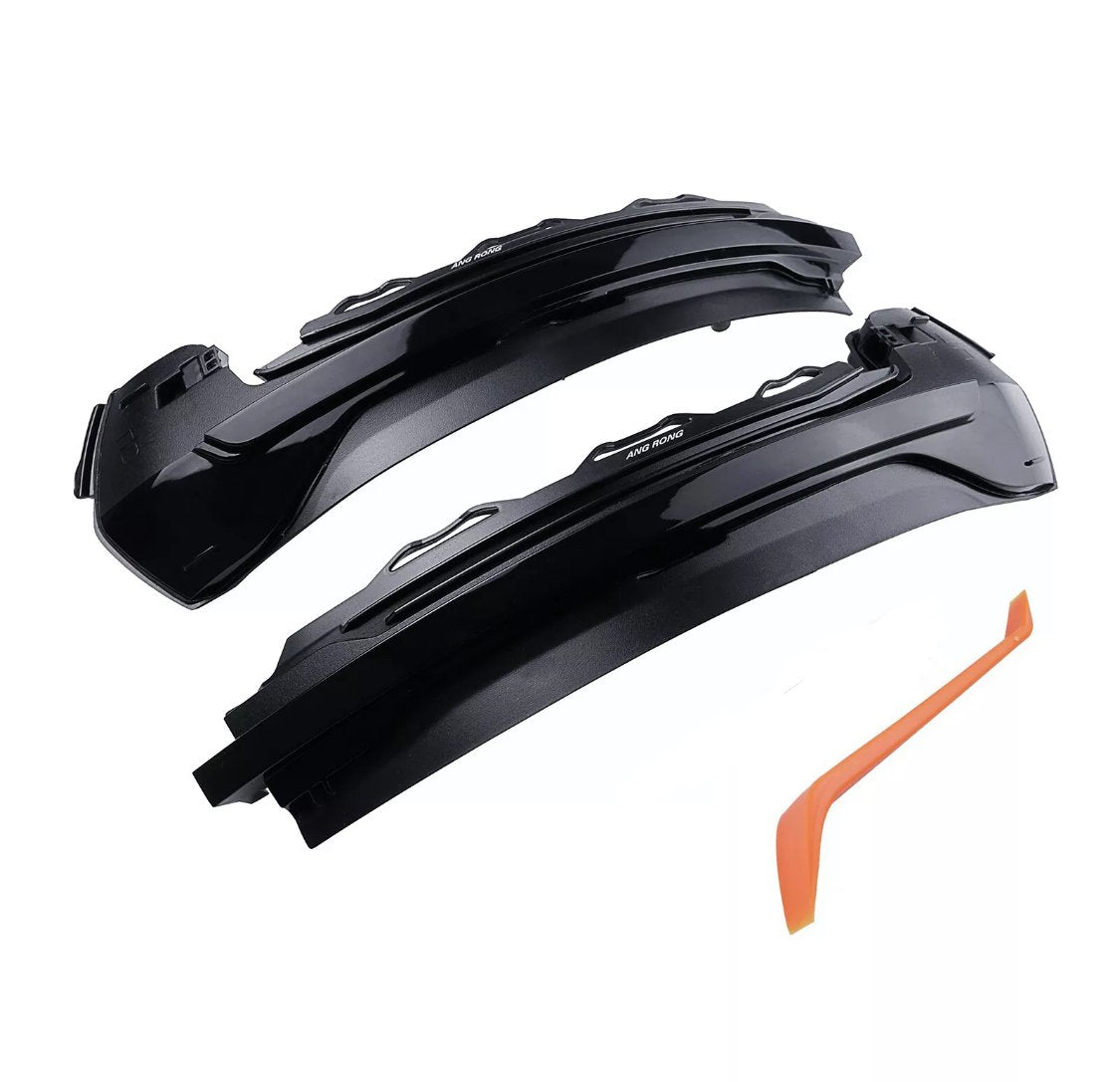 Two black automotive light covers, labeled "ANG RONG," rest near an orange plastic tool on a white background.
