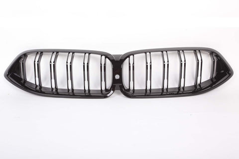 A black car grille with parallel vertical slats, forming a dual-kidney shape, is centered on a plain white background.