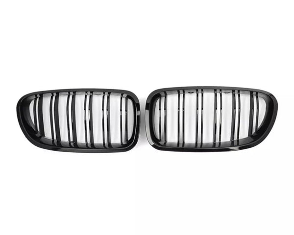 Two black, oval car grilles with vertical slats are positioned side by side against a plain white background.