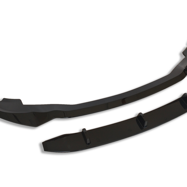 A pair of glossy black car lip spoilers lie side by side against a plain white background. The larger piece is curved, while the smaller piece is straighter with small protrusions.