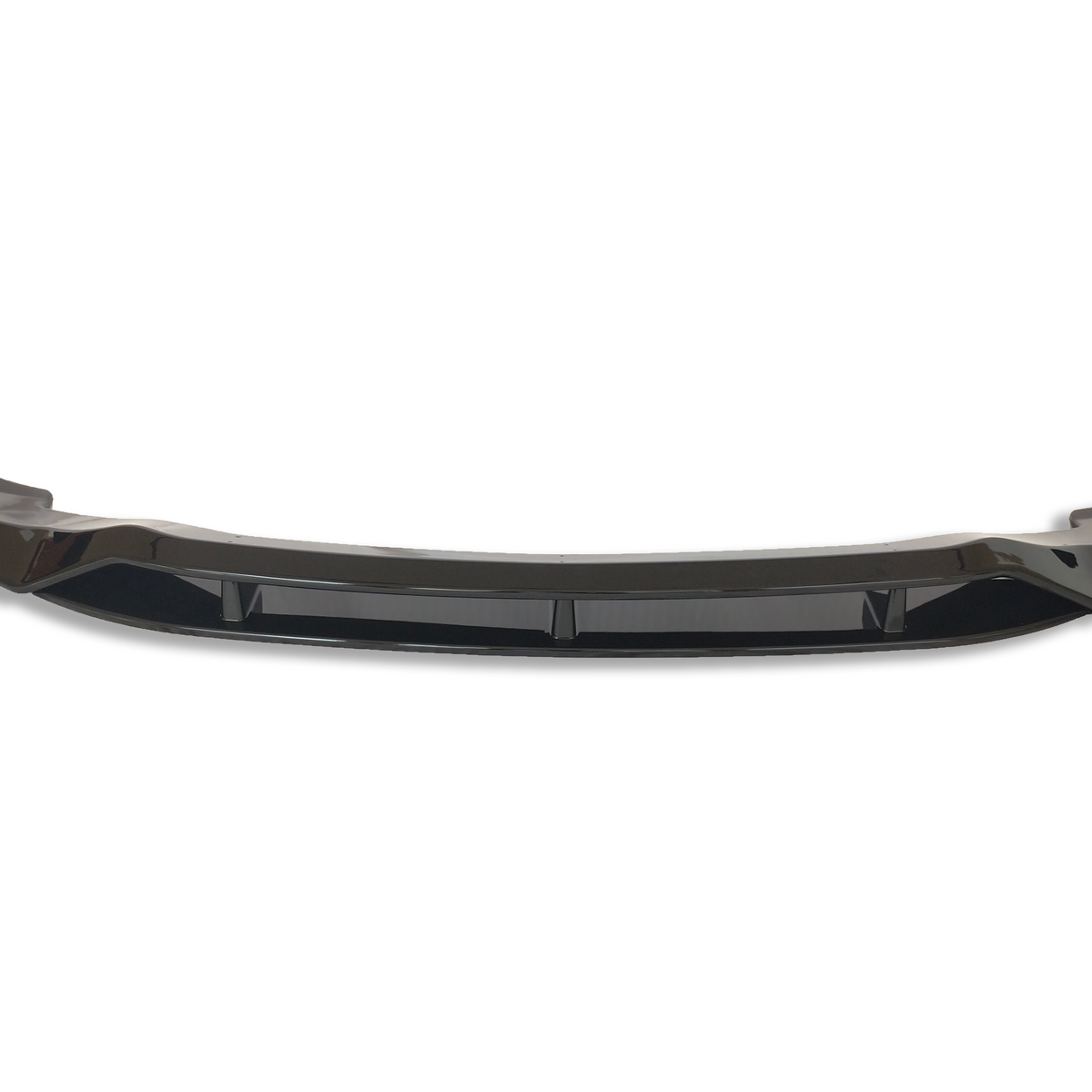A glossy black car front bumper lip with aerodynamic curves sits isolated on a white background, emphasizing its sleek design and enhancing vehicle aesthetics and performance.