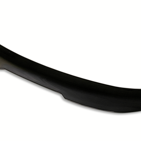 A black carbon fiber car spoiler with a subtle curvature sits against a plain white background, highlighting its aerodynamic design.