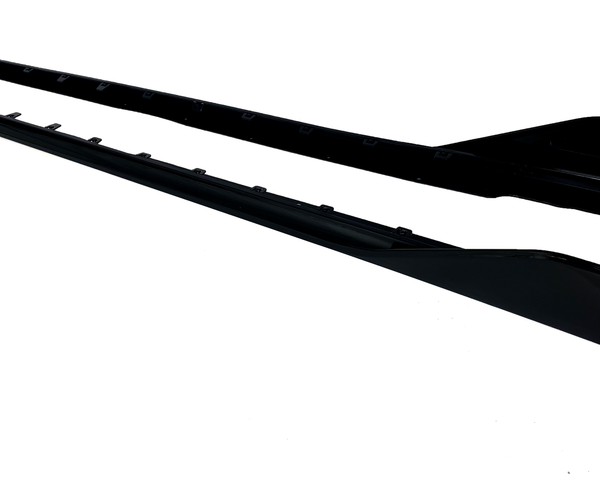 Two long, black car side skirts are positioned parallel on a white background, showcasing attachment points and a sleek, aerodynamic shape.