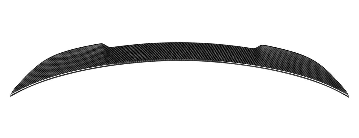 A black carbon fiber car spoiler rests horizontally against a plain white background, featuring a smooth, curved aerodynamic design.