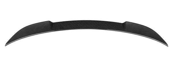 A black carbon fiber car spoiler rests horizontally against a plain white background, featuring a smooth, curved aerodynamic design.
