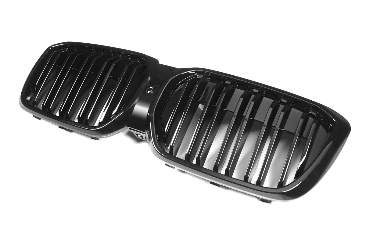 Black twin kidney-shaped car grille featuring vertical bars, resting on a plain white background.