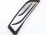A sleek, silver and black metal vent with curved lines rests on a white surface, suggesting a modern, aerodynamic design.