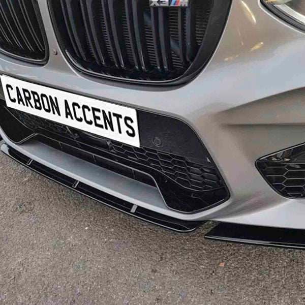 Car front bumper with a honeycomb grille and text reading "CARBON ACCENTS" on a license plate. It is parked on an asphalt surface, highlighting sleek design elements.