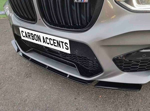 Car front bumper with a honeycomb grille and text reading "CARBON ACCENTS" on a license plate. It is parked on an asphalt surface, highlighting sleek design elements.