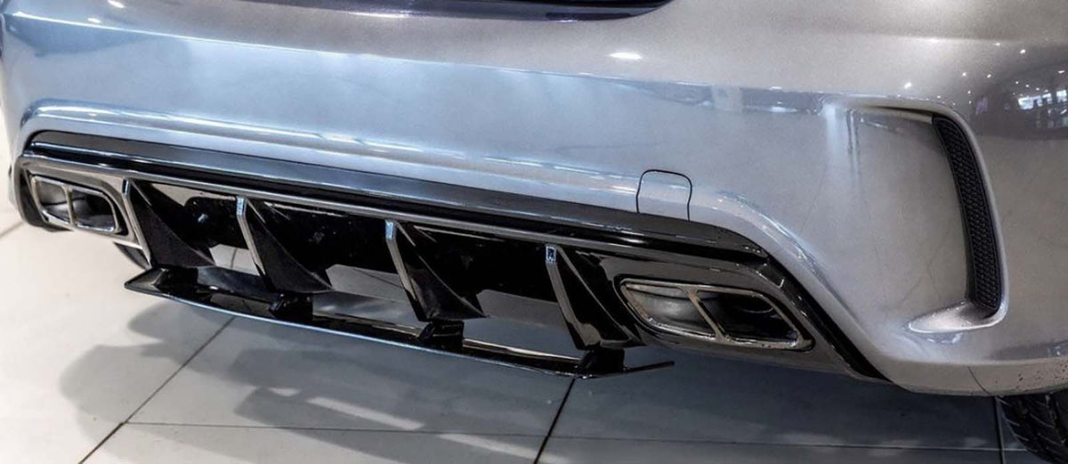 A car's rear bumper features dual exhausts and a black diffuser. The scene is indoors, with the vehicle parked on a glossy tiled floor.