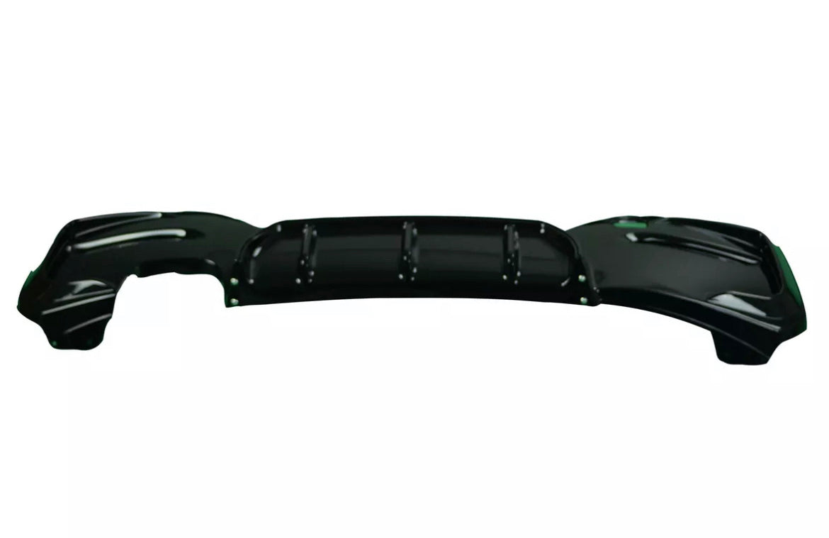 A glossy black car rear bumper with contoured edges lays flat against a plain white background, showing multiple mounting points and subtle ridges for aerodynamic design.