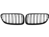 Two black kidney-shaped car grilles with vertical slats are positioned side by side against a plain white background.