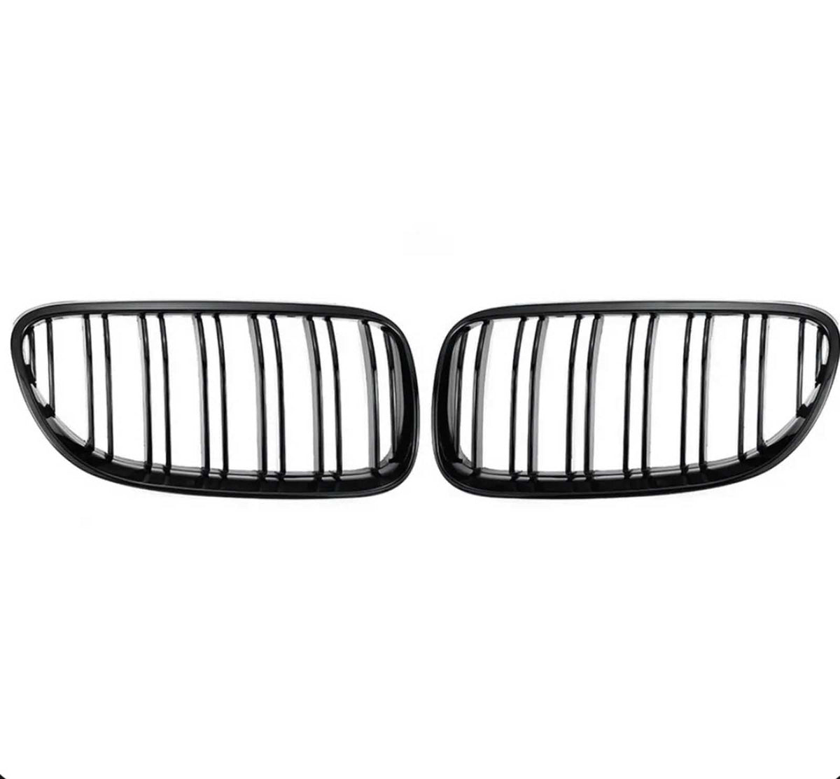 Two black kidney-shaped car grilles with vertical slats are positioned side by side against a plain white background.