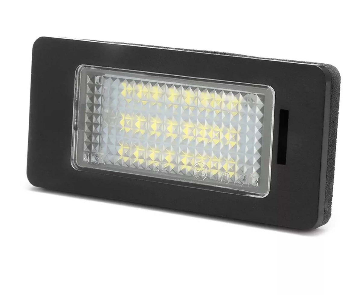 A rectangular LED light with a black frame, the LEDs illuminate through a textured lens. Set against a plain white background. Text on lens: “315, 101363.”