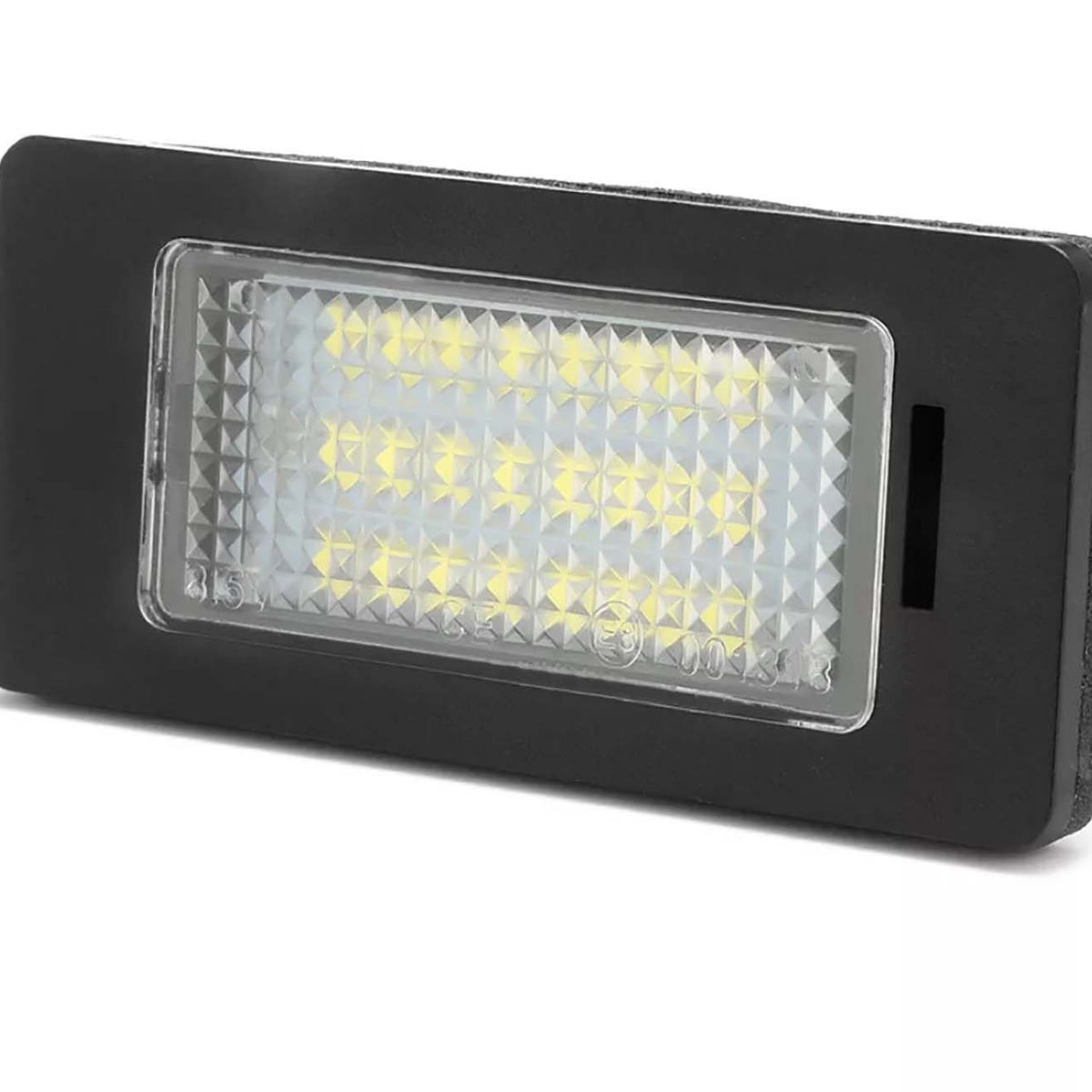 Rectangular LED light is shown, illuminated with multiple small yellow bulbs, encased in a textured clear cover. It's set in a black frame, likely suitable for automotive use.